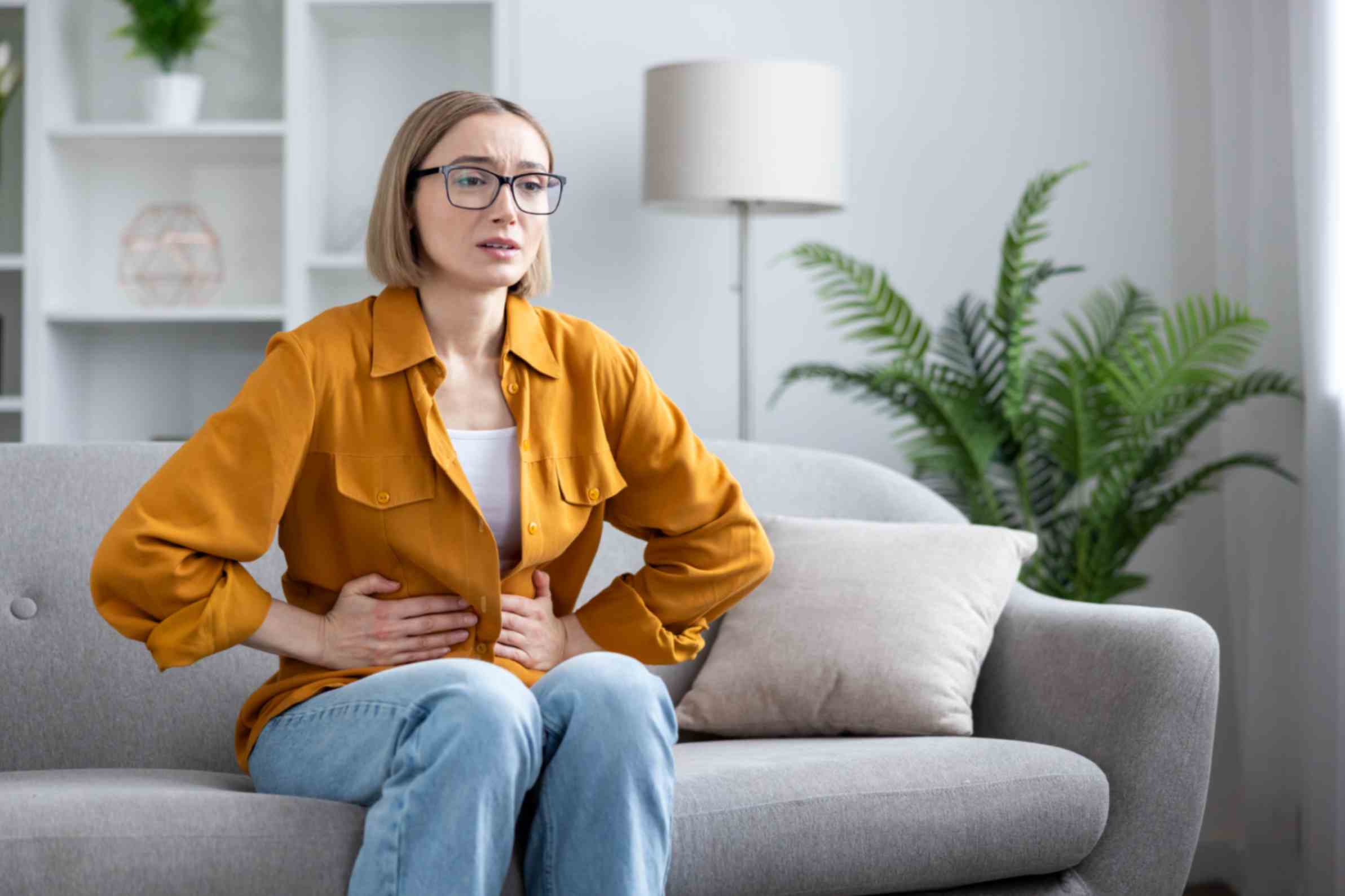 woman-at-home-holding-her-stomach-in-pain-and-discomfort