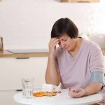 woman-measures-blood-pressure-with-a-headache-because-of-lack-of-vitamin-B12