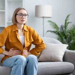 woman-at-home-holding-her-stomach-in-pain-and-discomfort