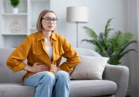 woman-at-home-holding-her-stomach-in-pain-and-discomfort