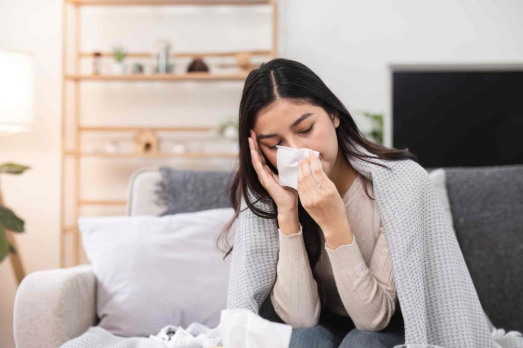 woman-with-a-cold-blowing-her-nose-at-home