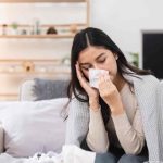woman-with-a-cold-blowing-her-nose-at-home