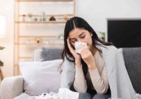 woman-with-a-cold-blowing-her-nose-at-home